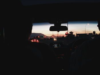 Silhouette people on street seen through car windshield