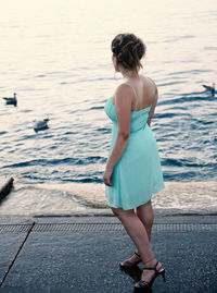 Rear view of woman standing at beach