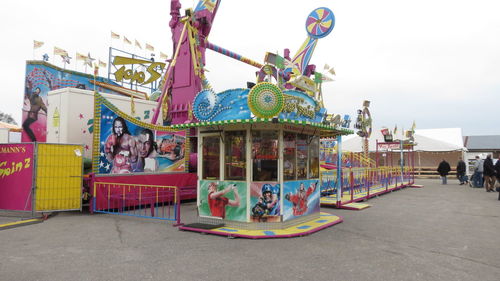 People at amusement park against sky