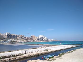 City by sea against clear blue sky