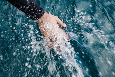 Low section of man swimming in sea