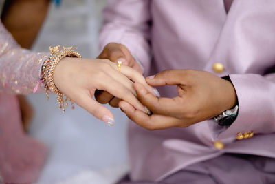 Midsection of couple holding hands