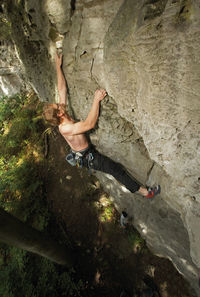 Young man climbing limestone cliff in north germany