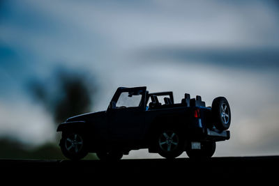 Toy car against sky at dusk