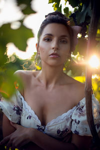 Portrait brunette woman in a white dress stands in a vineyard in summer in italy