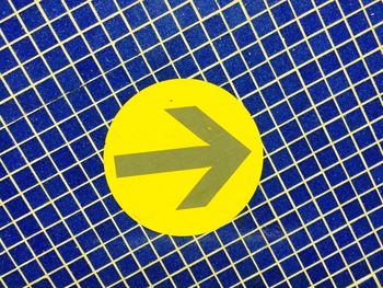 Close-up of yellow arrow sign