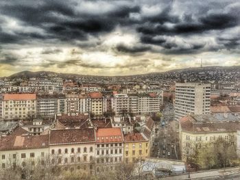 Buildings against cloudy sky