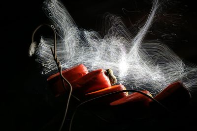 Close-up of illuminated lighting equipment against black background