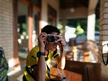 Young man taking photos from porch