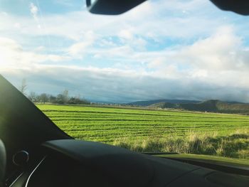 Scenic view of field seen through car windshield