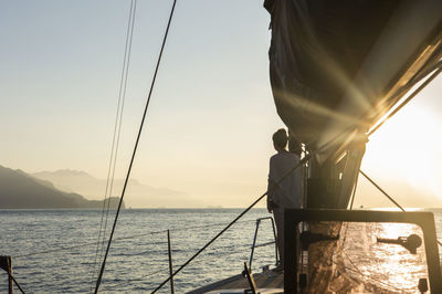 Sailboat sailing on sea against sky during sunset