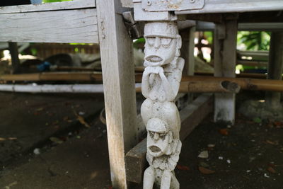 A photo of a the legs of a chair with unique carvings in the form of miniature humans