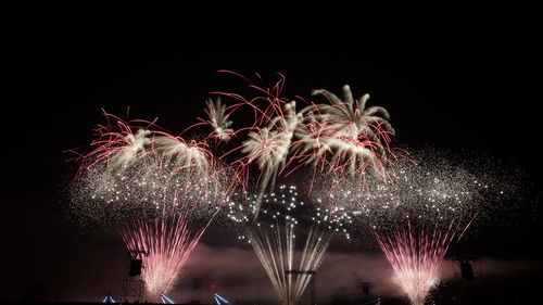 Low angle view of firework display at night