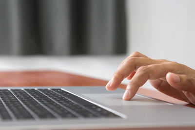 Cropped hands using laptop on table