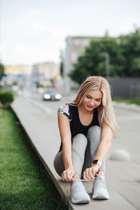 Young woman sitting on road