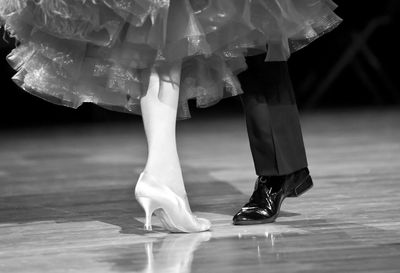 Low section of couple performing tango on stage