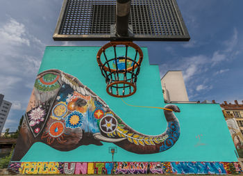 Low angle view of graffiti on wall against sky