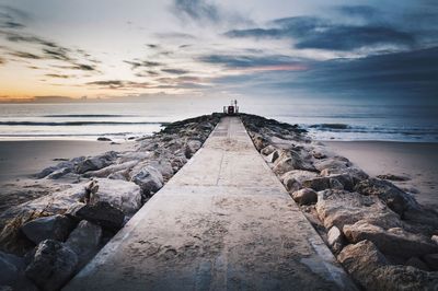 Footpath leading towards sea at sunset