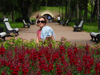 Portrait of girl sitting on flowering plants