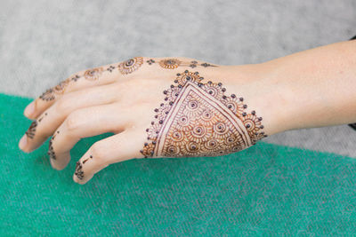 Midsection of woman with tattoo on hand