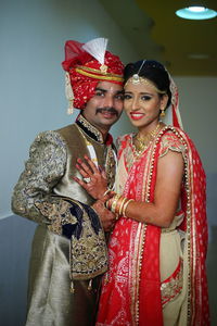 Smiling young couple standing against wall