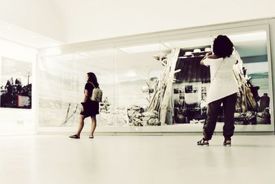 Rear view of women walking in shopping mall