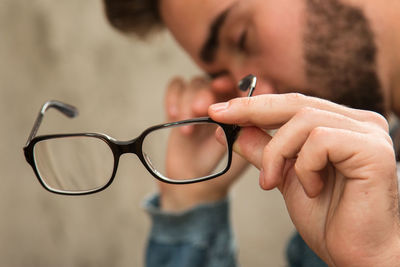 Close-up of man holding eyeglasses