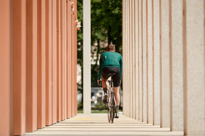 Rear view of man walking on footpath