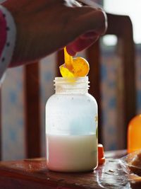 Close-up of hand holding drink in glass on table