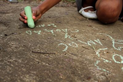 Person writing on ground with chalk
