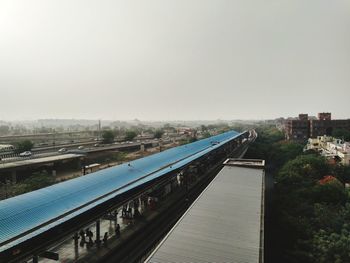 High angle view of railroad tracks by buildings against sky