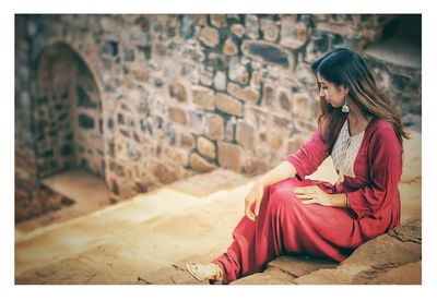 Woman sitting against wall