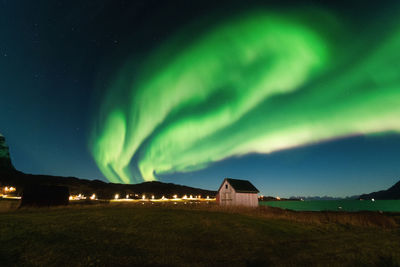 Scenic view of building against northern lights at night