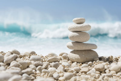 Stack of pebbles on beach against sky