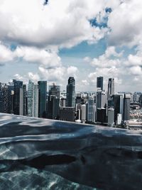 Buildings in city against cloudy sky