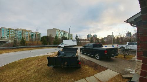 Cars on city street against sky