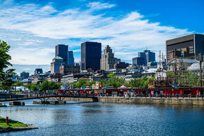 River by buildings against sky in city