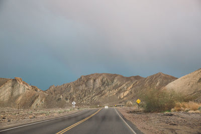 Road amidst desert against sky