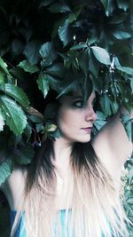 Close-up of young woman with tree