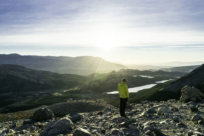 Rear view of woman on mountain against sky