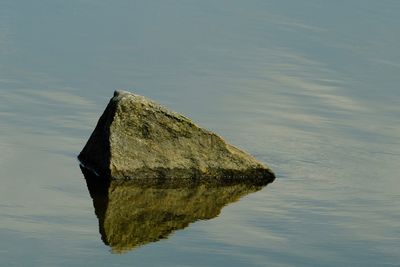 Reflection of rocks in lake against sky