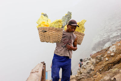 Full length of man holding wicker basket