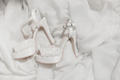 High angle view of white shoes on bed