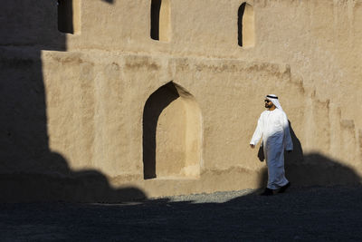 Rear view of man standing by building