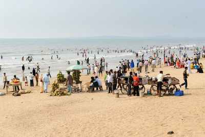 People at beach against sky