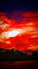 Silhouette landscape against dramatic sky during sunset