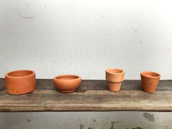 Potted plants on wooden floor against wall