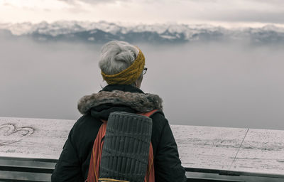 Rear view of a man overlooking calm lake