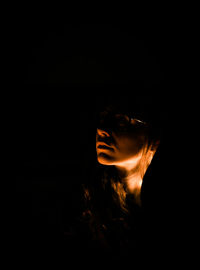 Young woman looking away against black background