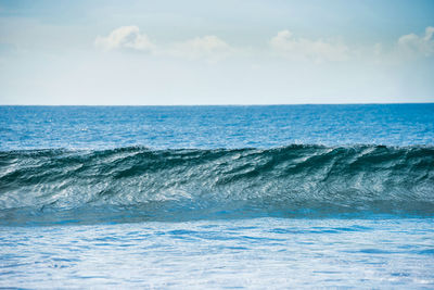 Calm blue seascape with white surf wave on foreground